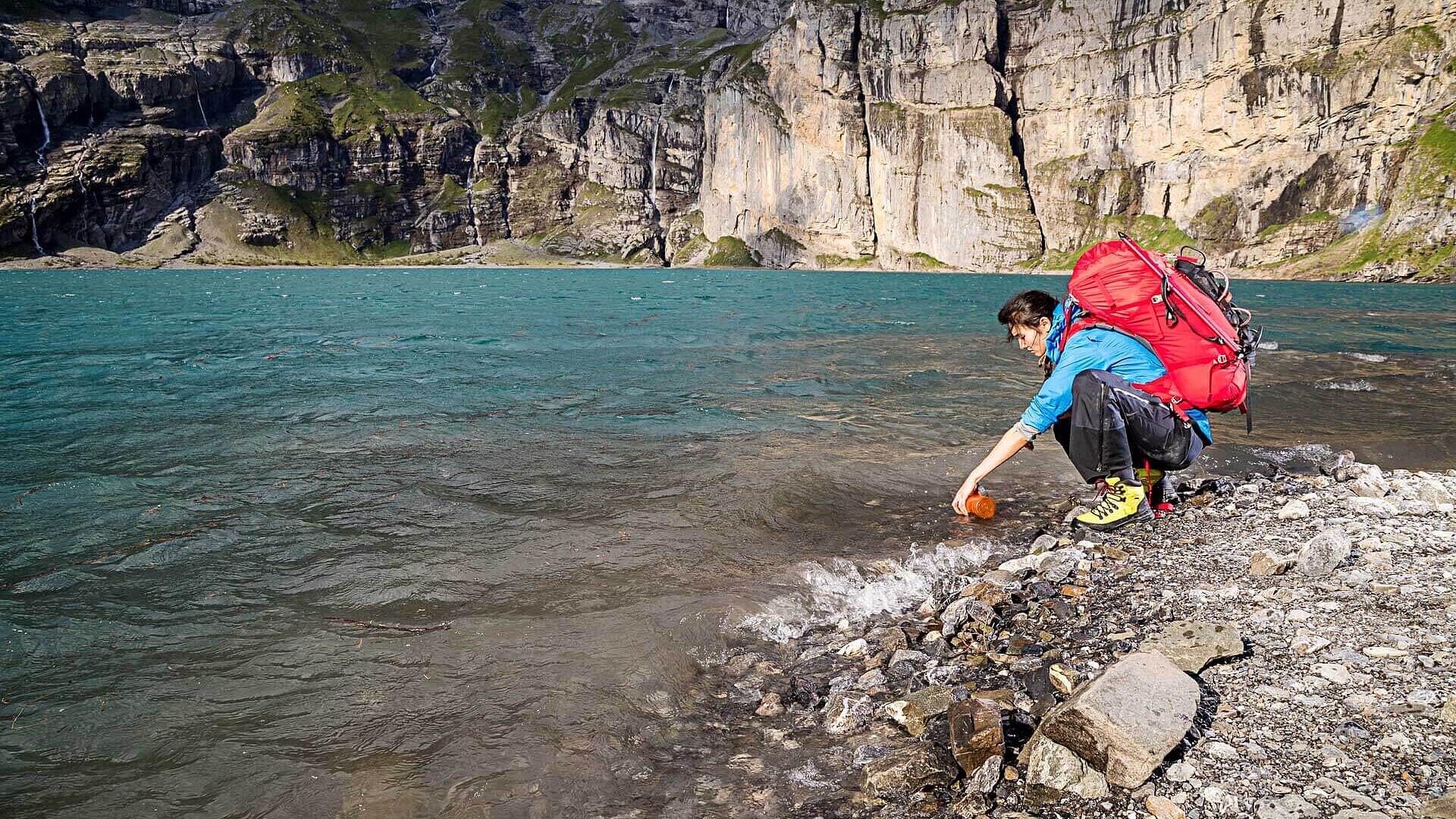  Eine Wanderin füllt ihre Trinkflasche auf