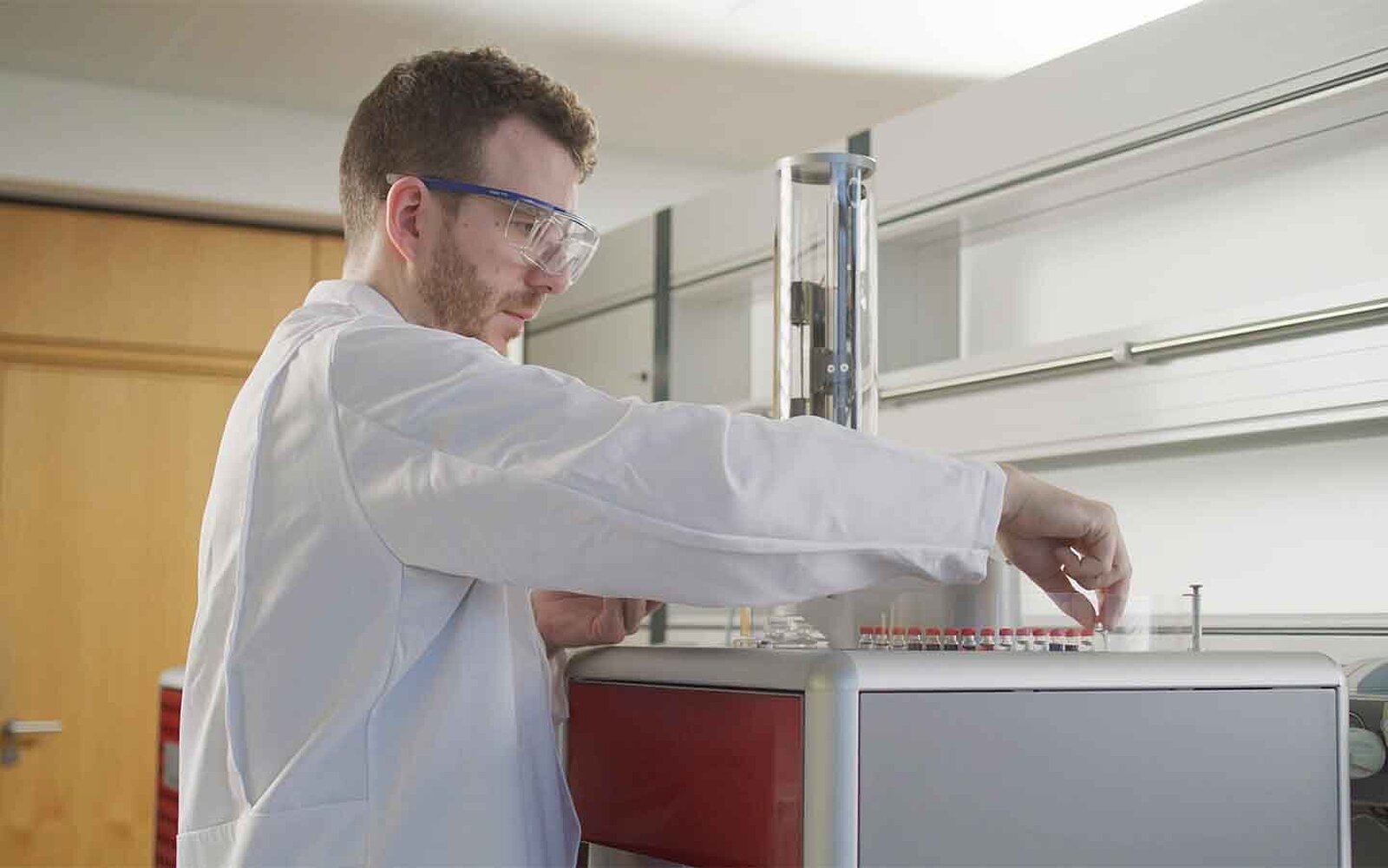 Male lab employee is placing samples on an oxygen analyzer