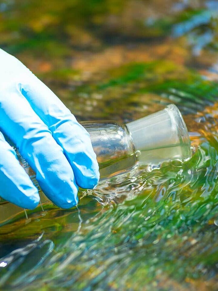 Drawing water into a research flask from a stream