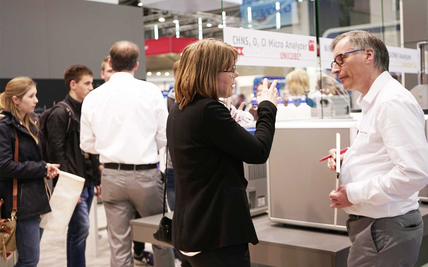 Personen im Gespräch auf dem Elementar analytica Stand