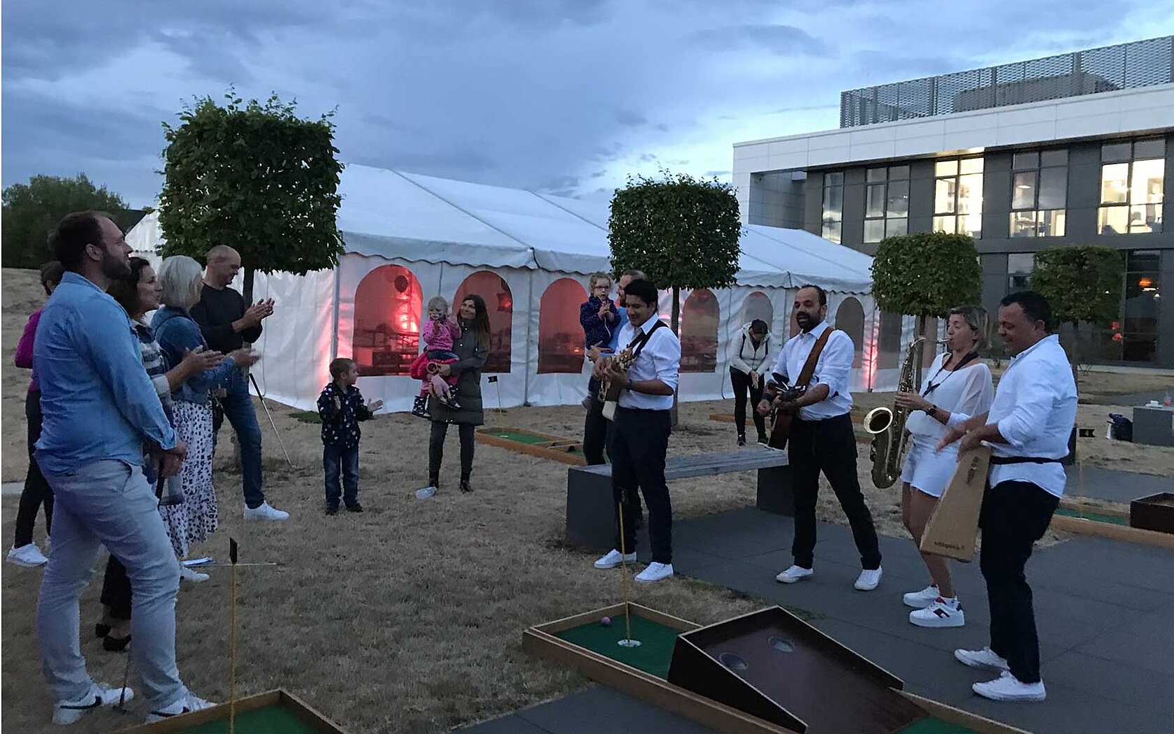 A band + other people standing in front of a lightened wall