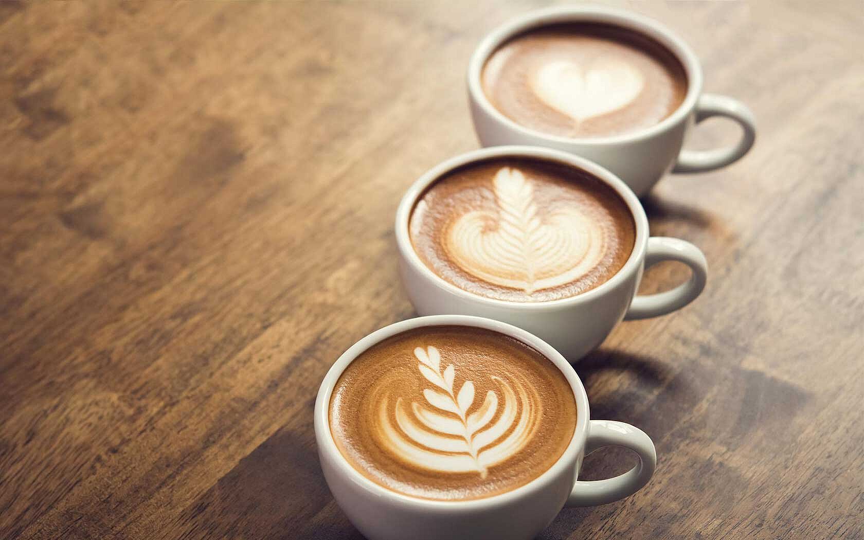Drei Tassen Barista Kaffee auf holzigem Untergrund