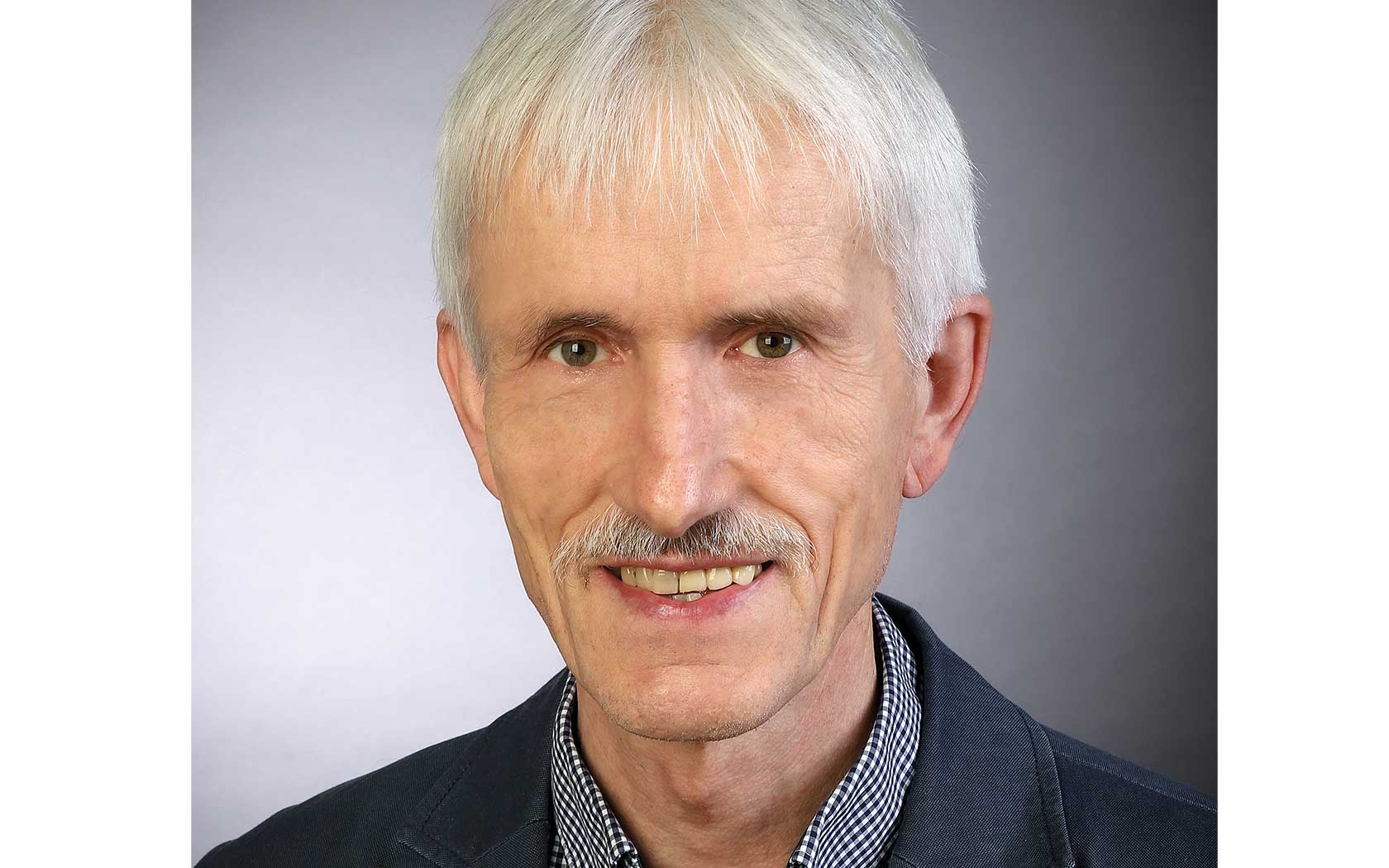 Professor Dr. Honermeier vor einem grauen Hintergrund